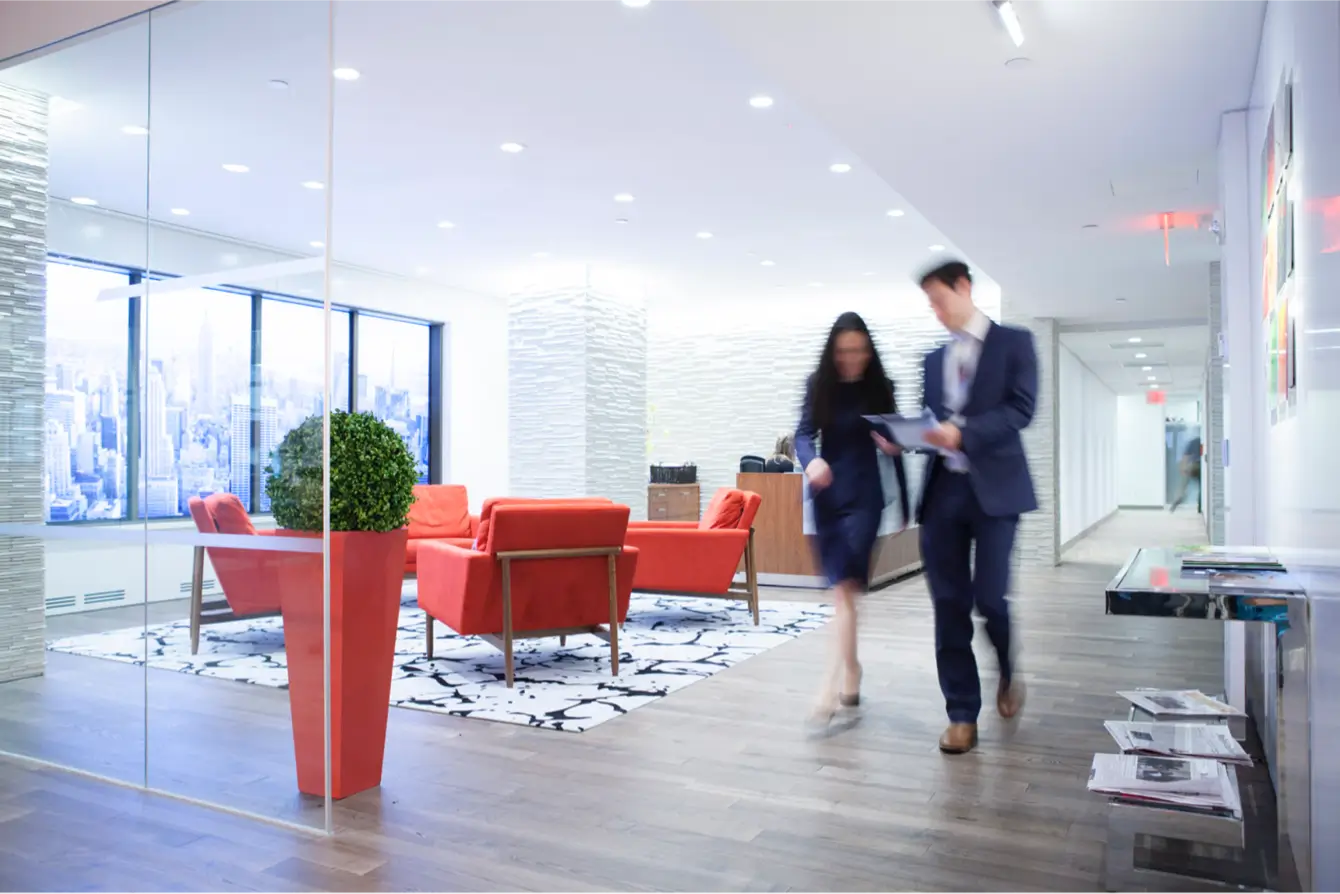 a man and woman walk down a hallway while talking